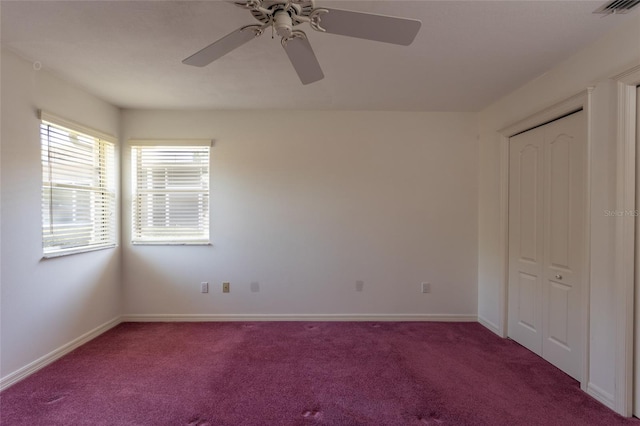 unfurnished bedroom featuring visible vents, a closet, carpet, baseboards, and ceiling fan