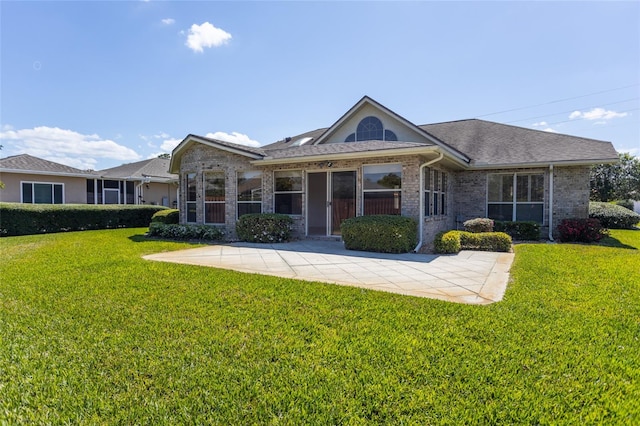 view of front facade featuring brick siding, a front lawn, and a shingled roof