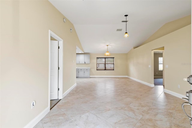 unfurnished room with baseboards, lofted ceiling, and visible vents