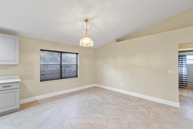 unfurnished dining area featuring lofted ceiling, light tile patterned floors, and baseboards