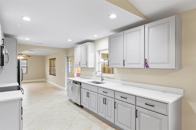 kitchen with light countertops, recessed lighting, arched walkways, stainless steel appliances, and a sink