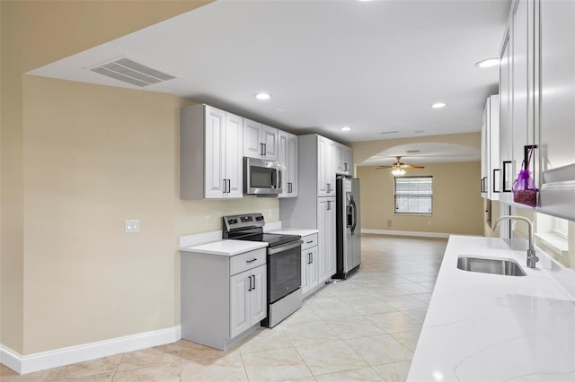 kitchen with a ceiling fan, visible vents, light tile patterned flooring, a sink, and appliances with stainless steel finishes