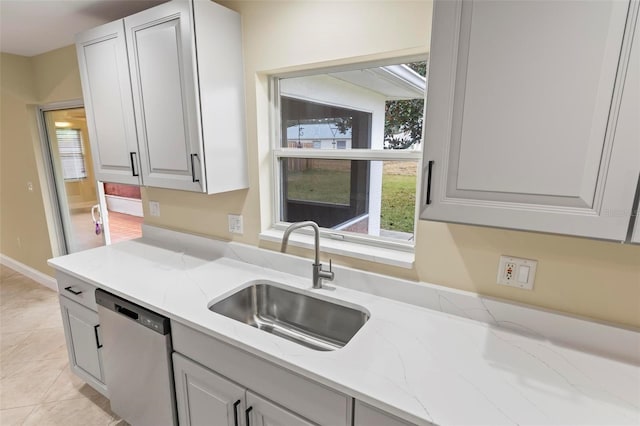 kitchen featuring a sink, light stone countertops, dishwasher, and light tile patterned floors