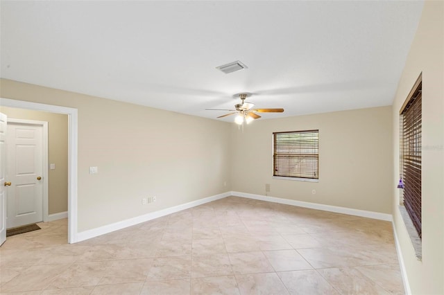 unfurnished room with light tile patterned floors, a ceiling fan, visible vents, and baseboards