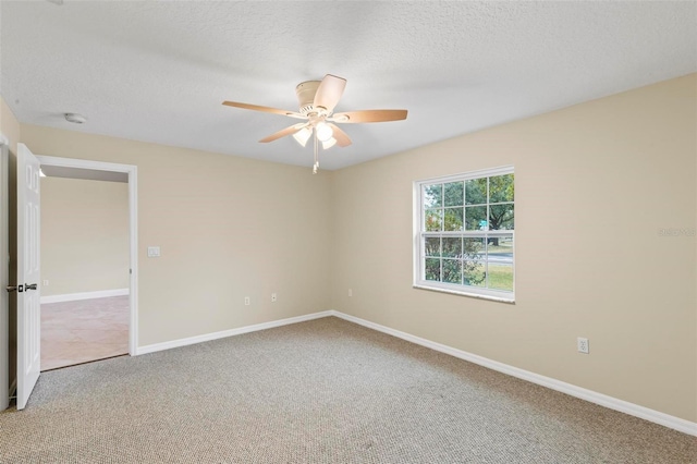 spare room with baseboards, carpet floors, a textured ceiling, and ceiling fan