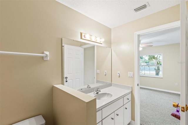 half bath featuring visible vents, vanity, and baseboards