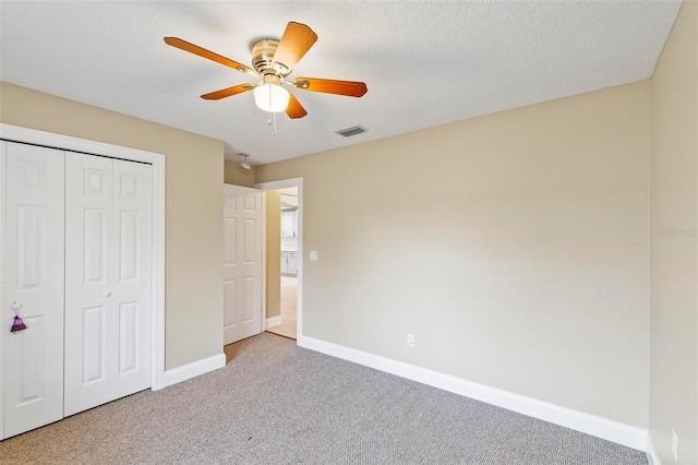 unfurnished bedroom with visible vents, a closet, carpet floors, baseboards, and ceiling fan