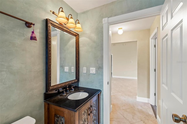 half bath featuring vanity, toilet, and baseboards