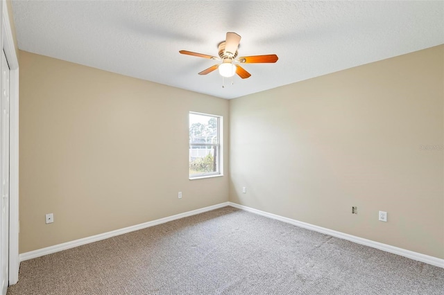 spare room with baseboards, a textured ceiling, ceiling fan, and carpet flooring