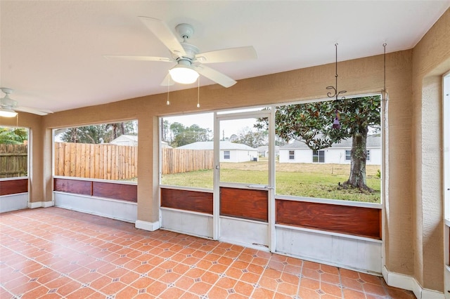 unfurnished sunroom with a ceiling fan