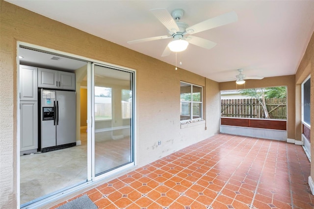 unfurnished sunroom with ceiling fan