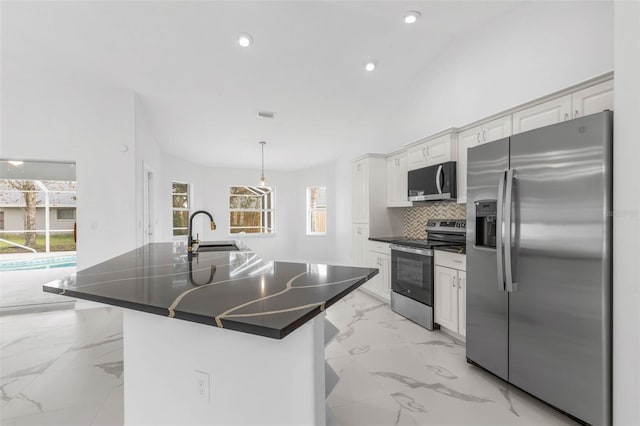 kitchen featuring a sink, stainless steel appliances, marble finish floor, dark countertops, and tasteful backsplash