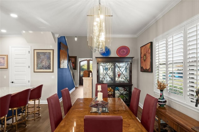 dining room featuring crown molding, a notable chandelier, wood finished floors, and baseboards