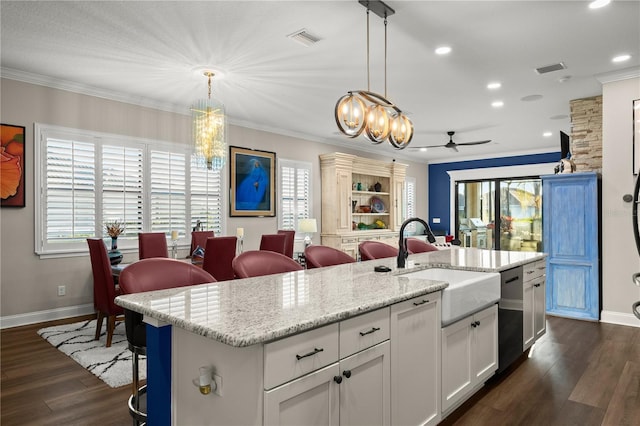 kitchen featuring visible vents, ceiling fan with notable chandelier, crown molding, and dark wood-style flooring