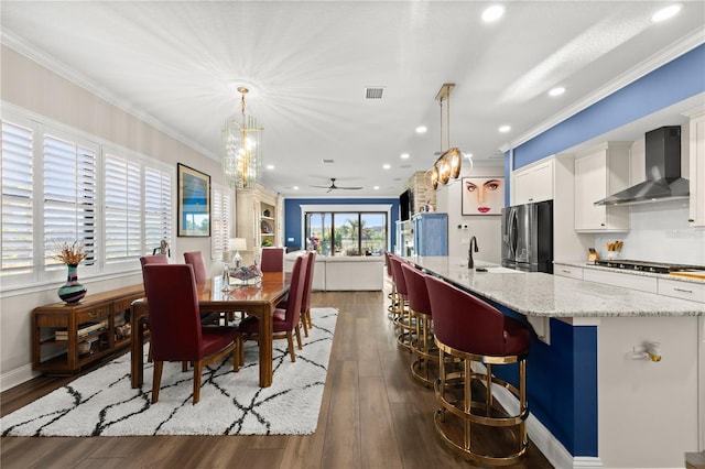 dining area featuring visible vents, ceiling fan with notable chandelier, and ornamental molding