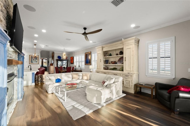 living area featuring visible vents, a fireplace, ceiling fan, and dark wood-style flooring