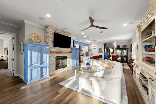 living room with dark wood-style floors, a fireplace, recessed lighting, ornamental molding, and ceiling fan