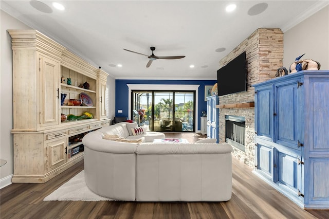 living area featuring wood finished floors, a fireplace, recessed lighting, ornamental molding, and ceiling fan