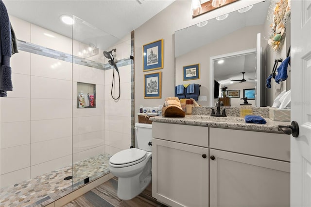 bathroom with vanity, a shower stall, toilet, and wood finished floors