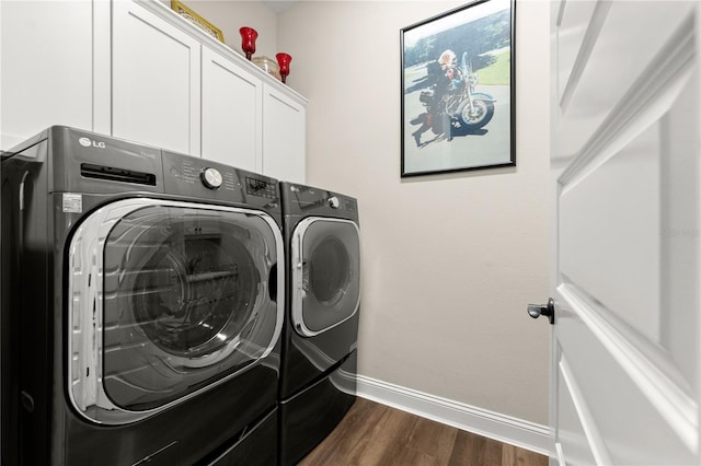 laundry area with cabinet space, baseboards, dark wood finished floors, and washing machine and clothes dryer