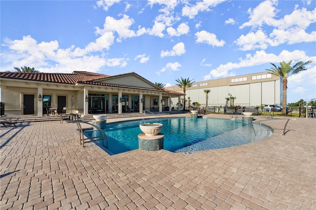 pool with a patio and fence