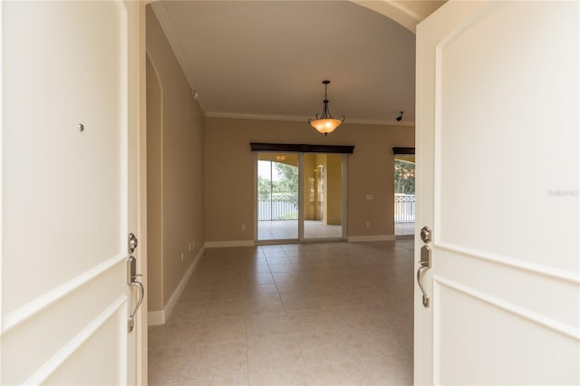 interior space featuring light tile patterned floors, baseboards, arched walkways, and ornamental molding