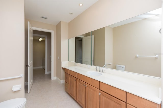 bathroom with tile patterned flooring, visible vents, baseboards, toilet, and vanity