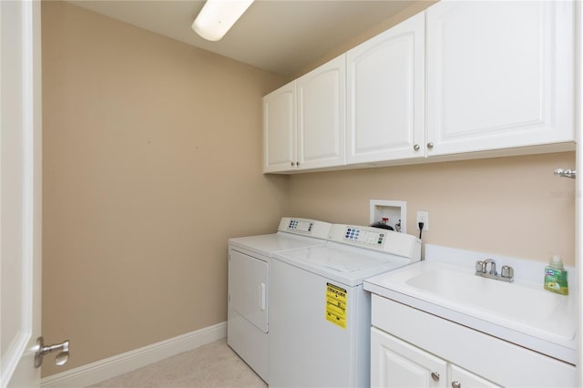 washroom with washer and clothes dryer, cabinet space, baseboards, and a sink