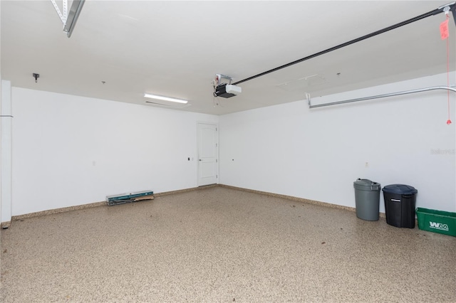 garage with a garage door opener and baseboards