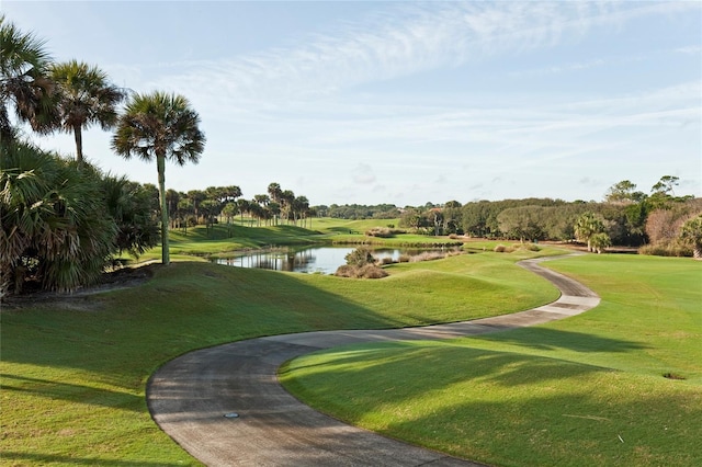 view of community featuring a water view, a lawn, and golf course view