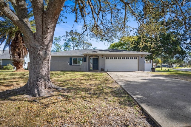 ranch-style home with stucco siding, a front lawn, a garage, and driveway