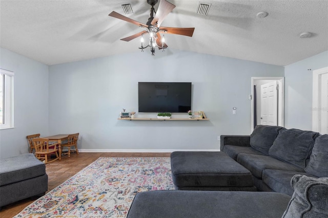 living room with visible vents, baseboards, ceiling fan, and vaulted ceiling