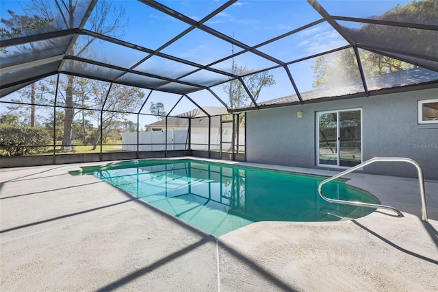 outdoor pool featuring glass enclosure and a patio