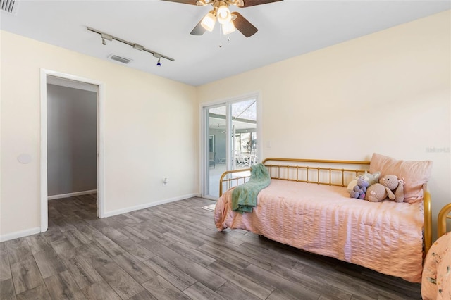 bedroom with visible vents, wood finished floors, baseboards, and access to outside