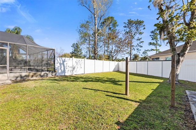 view of yard with a lanai and a fenced backyard