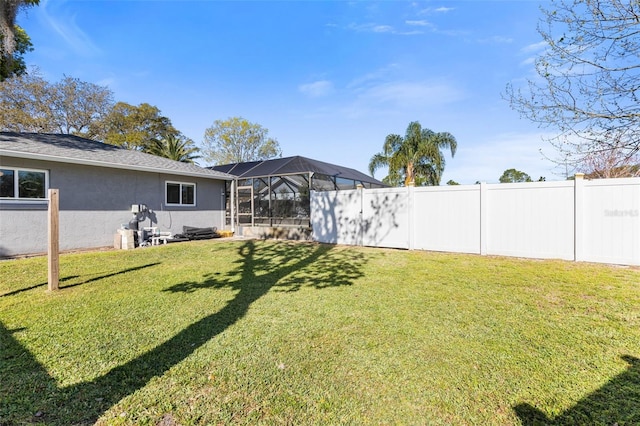 view of yard with a lanai and fence