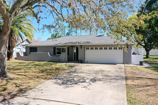 ranch-style house with stucco siding, an attached garage, concrete driveway, and a front lawn