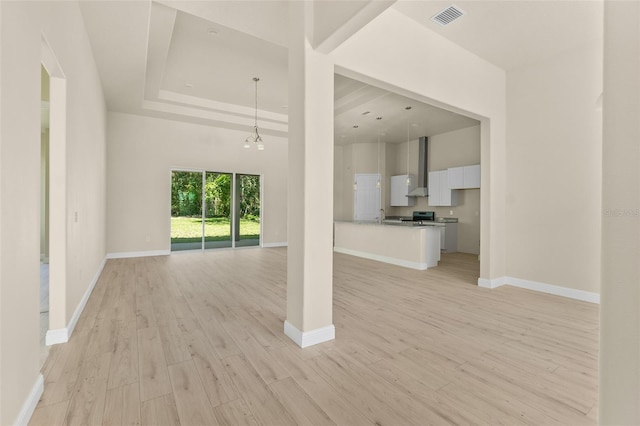 unfurnished living room featuring light wood finished floors, visible vents, and baseboards