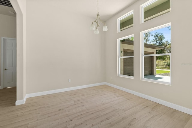 spare room with baseboards and light wood finished floors