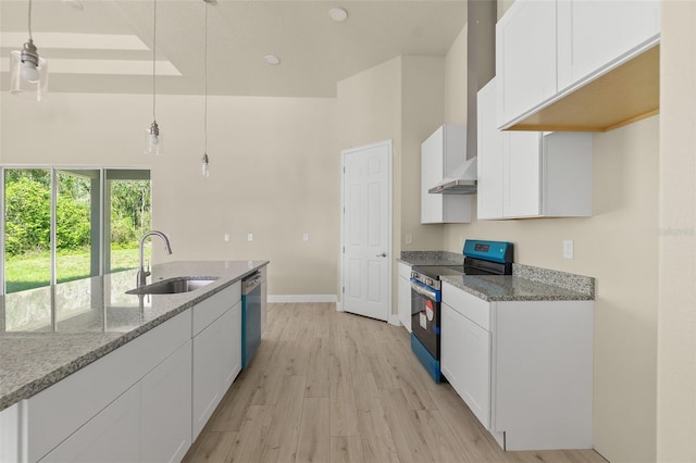 kitchen featuring a sink, light stone counters, appliances with stainless steel finishes, white cabinets, and wall chimney range hood