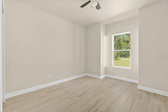 unfurnished room featuring baseboards, a ceiling fan, and light wood finished floors