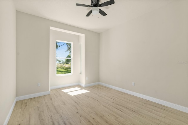 empty room featuring light wood finished floors, a ceiling fan, and baseboards