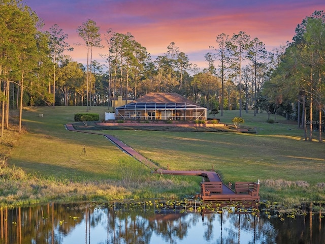 exterior space featuring a dock, a yard, and a water view