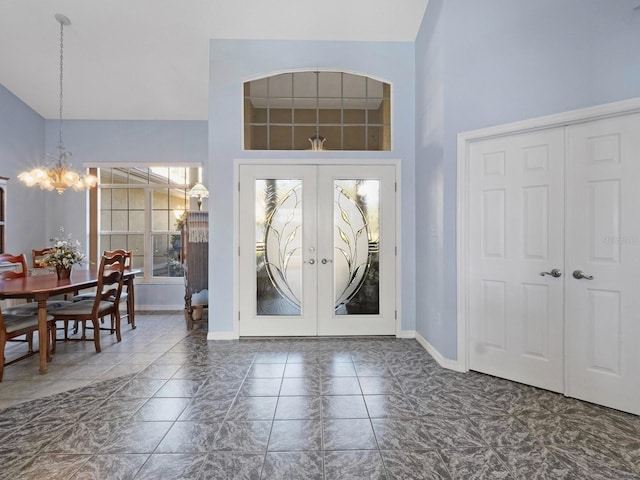 entryway with french doors, baseboards, a towering ceiling, and a chandelier