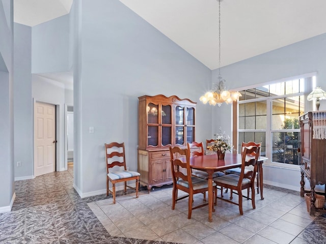 dining area with baseboards, high vaulted ceiling, and an inviting chandelier