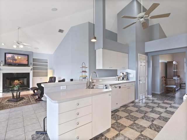 kitchen featuring visible vents, built in shelves, a sink, white dishwasher, and ceiling fan