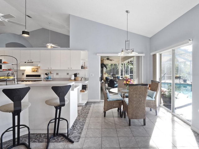 kitchen with gas stove, a ceiling fan, light countertops, under cabinet range hood, and white cabinetry