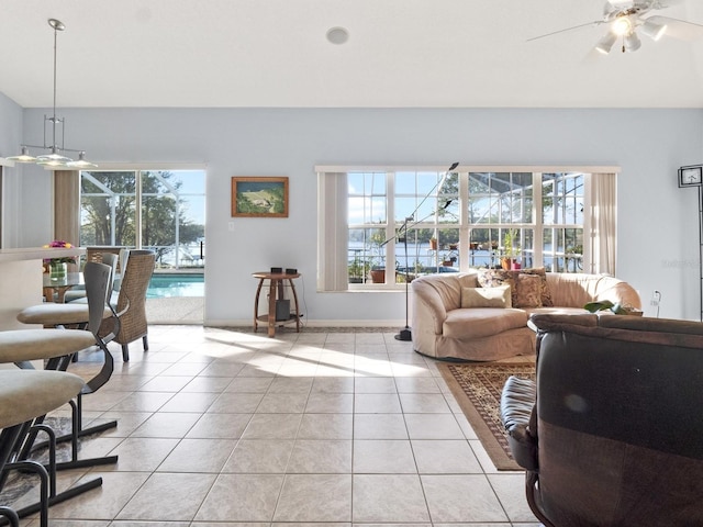 living area with light tile patterned flooring, baseboards, and a ceiling fan