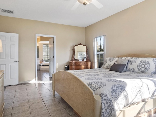 bedroom with tile patterned flooring, visible vents, ensuite bathroom, and a ceiling fan