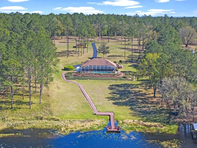 drone / aerial view with a wooded view and a water view